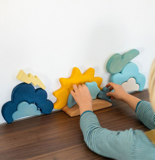 Kind spielt mit dem Bau Set Wetter von Grimms Holzspielzeug